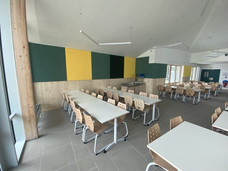 feutre acoustique vert, jaune et noir collé au mur dans restaurant scolaire